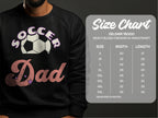 A man wears a trendy Soccer Dad sweatshirt with a soccer ball design from Garment Graphics. Next to him is the size chart for the Gildan 18000 heavy blend crewneck, featuring unisex sizing and measurements in inches.
