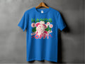 Garment Graphics presents a blue T-shirt on a hanger with a bold design of a woman in a hat, finger to lips, surrounded by flowers. It features HANDS OFF! text and Wild Side in smaller print with hearts and stars. Available in family sizes for all.