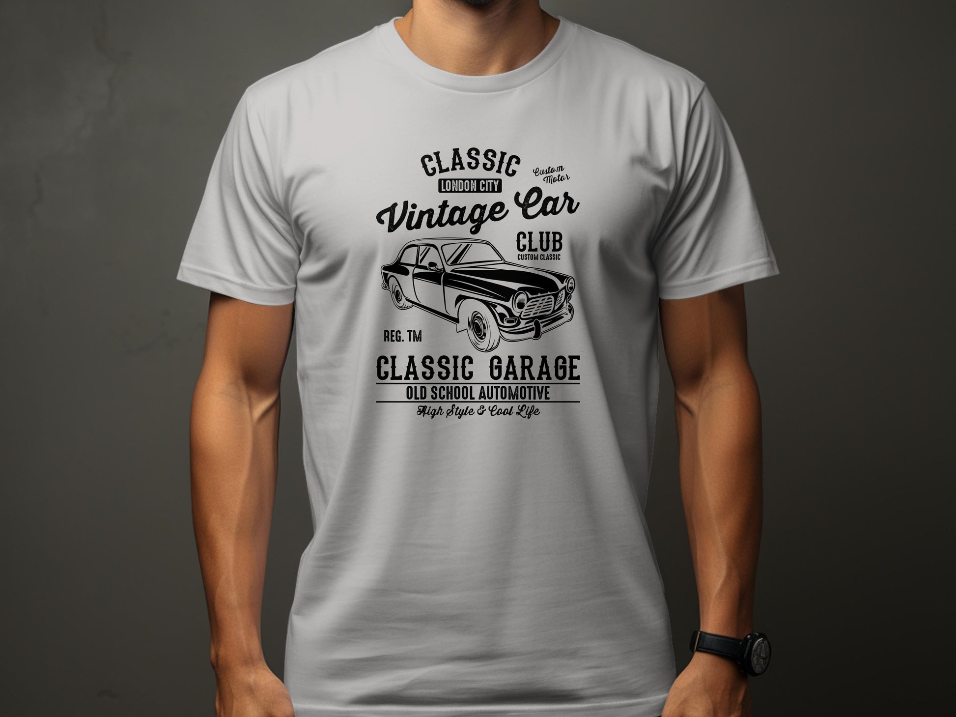 A person wearing a Garment Graphics white T-shirt with a vintage car graphic and the phrases Classic London City Vintage Car Club and Classic Garage Old School Automotive, featuring retro automotive elements like an illustrative classic car and decorative text.