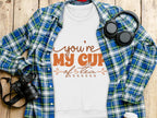 A white Youre My Cup of Tea t-shirt from Garment Graphics is displayed on a wooden surface, surrounded by a plaid shirt, headphones, camera, and coffee cup, making it perfect for tea enthusiasts and cozy sweatshirt lovers.