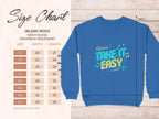 This image displays the size chart for the Garment Graphics crewneck sweatshirt, with Take It Easy graphic on blue Gildan 18000 fabric. Unisex sizing ranges from S to 5XL and offers detailed width and length dimensions in inches.