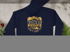 Garment Graphics navy golf hoodie with funny quote: If hes got cut-off clubs in his truck or a camper in his driveway, I dont hire him. An ideal gift displayed flat next to green and yellow leaves on light gray.
