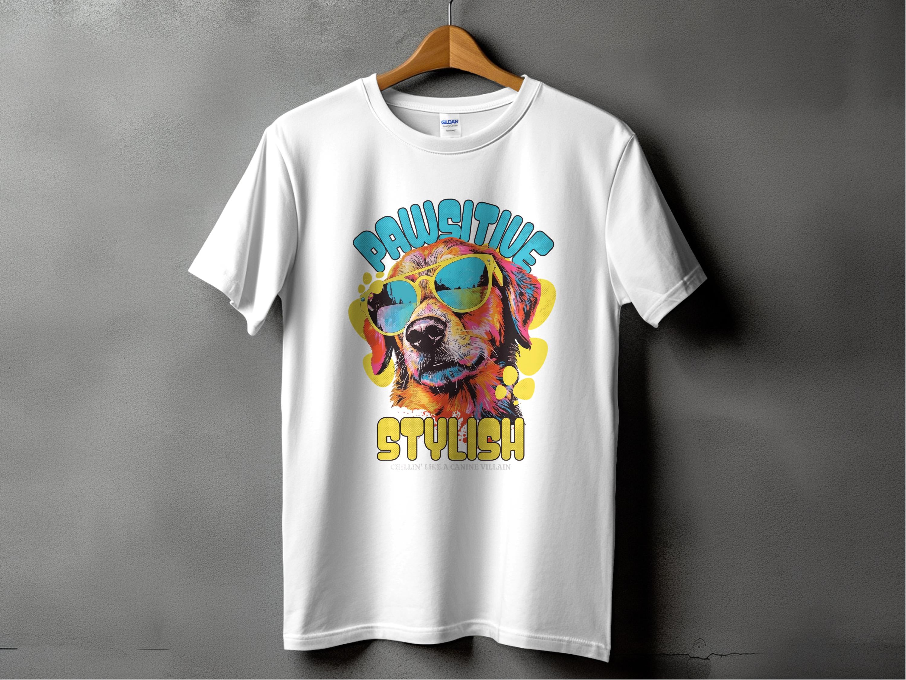 Garment Graphics white dog t-shirt on a hanger showcases a vibrant graphic of a dog with sunglasses, reading Chillin Like A Canine Villain. Against a gray backdrop, this shirt exudes paw-sitive style.