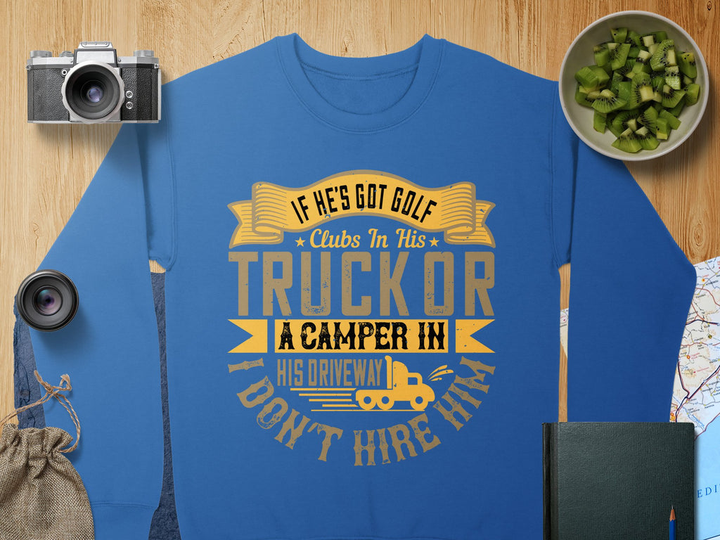 Garment Graphics blue sweatshirt features a humorous quote in yellow and white: If hes got golf clubs in his truck or a camper in his driveway, I dont hire him, surrounded by visuals like a camera, kiwi slices, map, lens, book, and burlap sack for a casual vibe.