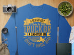 Garment Graphics blue sweatshirt features a humorous quote in yellow and white: If hes got golf clubs in his truck or a camper in his driveway, I dont hire him, surrounded by visuals like a camera, kiwi slices, map, lens, book, and burlap sack for a casual vibe.