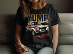 Dressed in jeans, a person relaxes on a couch wearing a black Garment Graphics T-shirt featuring a bold vintage racing car design with YUMP above it, embodying the retro T-shirt vibe. Their long hair cascades over one shoulder, enhancing the casual look.