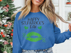 A person in a blue Garment Graphics sweatshirt featuring Happy St. Patricks Day and clover kiss designs stands near a decorated Christmas tree, embracing the festive spirit.