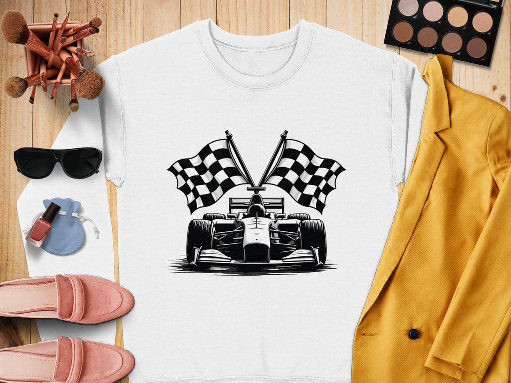 Flat lay showcasing Garment Graphics white shirt with checkered flag print, styled with pink loafers, a mustard jacket, sunglasses, makeup brushes, eyeshadow palette, nail polish, and a small pouch on a wooden surface.