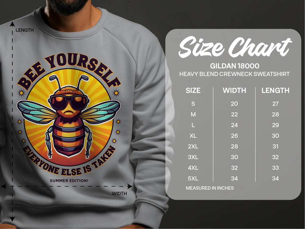 Someone wears a gray Garment Graphics sweatshirt with a bee graphic and the text Bee Yourself, Everyone Else Is Taken. This Summer Edition is unisex and follows the Gildan 18000 size chart, available in sizes S to 5XL.