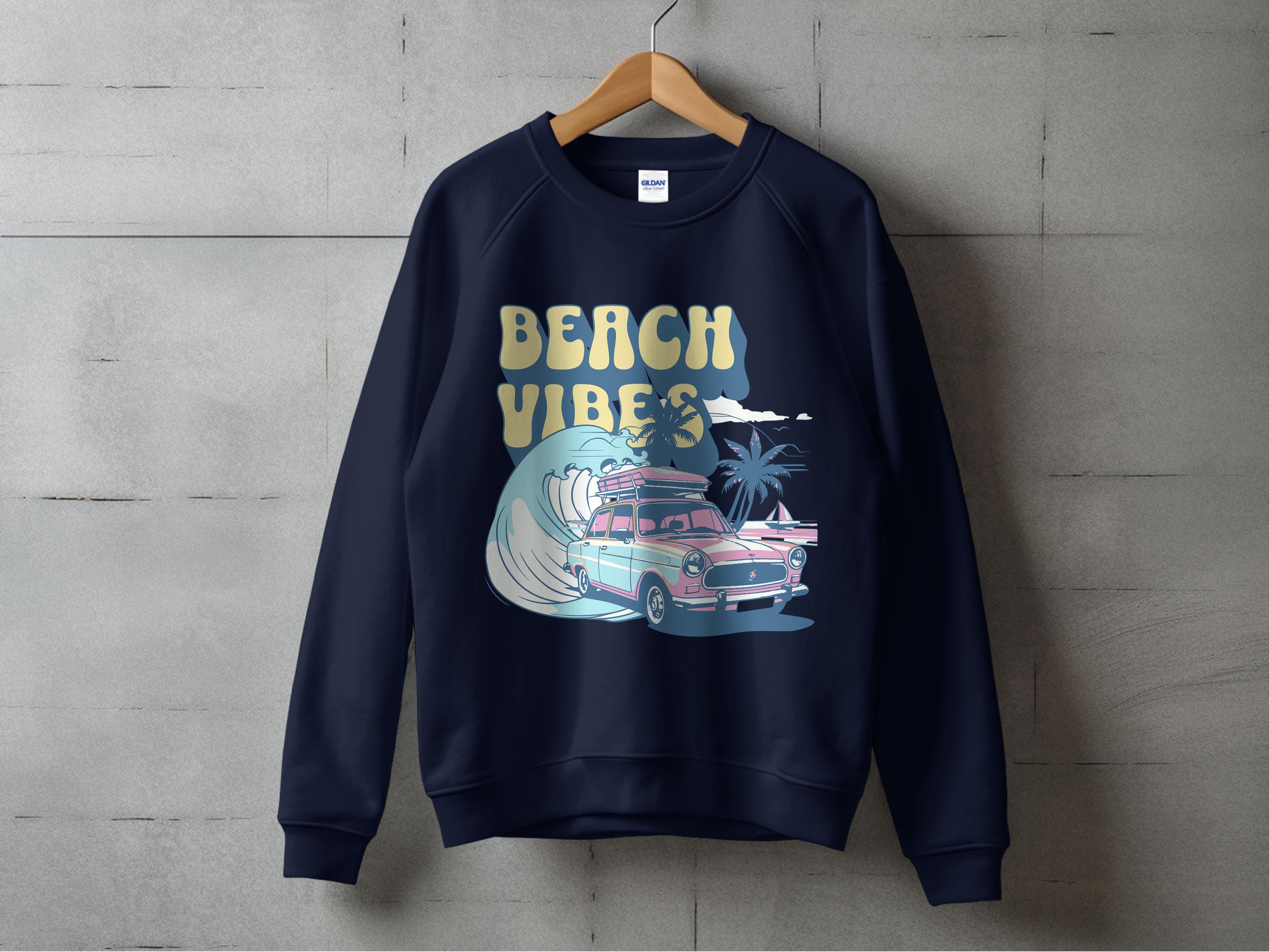 A navy Garment Graphics sweatshirt hangs on a wooden hanger, featuring a vintage car graphic with surfboards, ocean waves, and palm trees, along with Beach Vibes in stylized text. This unisex piece is perfect for lovers of classic graphic sweatshirts.