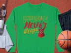 Garment Graphics offers a vibrant green sweatshirt featuring Music Never Sleeps and a red electric guitar design. Styled with a basketball, black shorts, water bottle, and folded gray towel, its perfect for music enthusiasts who love to stay active.