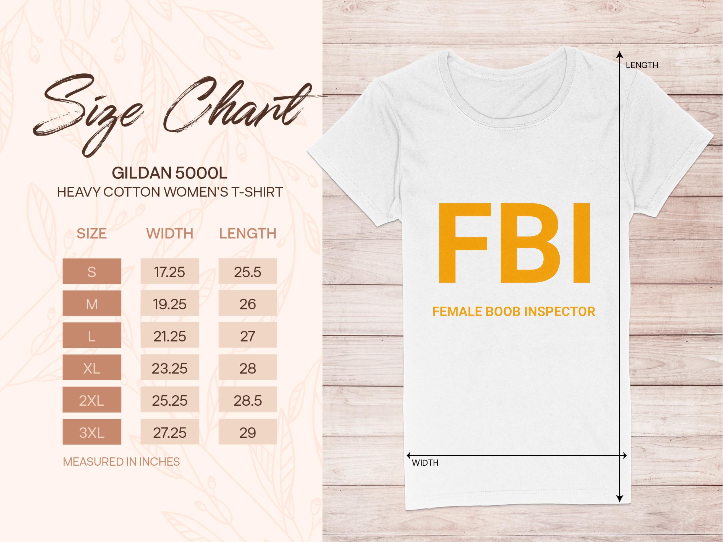 The white FBI Female Boob Inspector T-Shirt by Garment Graphics, ideal as a gag gift, showcases bold orange text. A size chart for womens sizing from Gildan 5000L (S to 3XL) is included on the left. The background features a light wood texture.