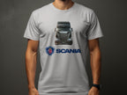 A truck enthusiast sports a gray T-shirt featuring a Scania truck image and logo by Garment Graphics, set against a plain dark backdrop, with a wristwatch on their left arm.