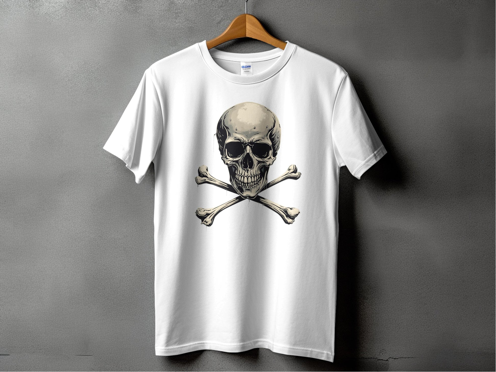 A white Garment Graphics T-shirt on a wooden hanger set against a gray background features a striking skull and crossbones design, perfect for bold graphic T-shirt enthusiasts.