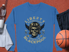 The Liberty Motorcycles Specialist Blackpool 2023 blue sweatshirt by Garment Graphics showcases a skull with goggles and a helmet. Pair it with a white towel, water bottle, black shorts, and an orange basketball for a standout look.