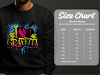 A person sports a Garment Graphics black sweatshirt with vibrant street art-themed I Love Graffiti text. The Gildan 18000 size chart is shown, listing sizes S to 5XL with width and length measurements in inches.