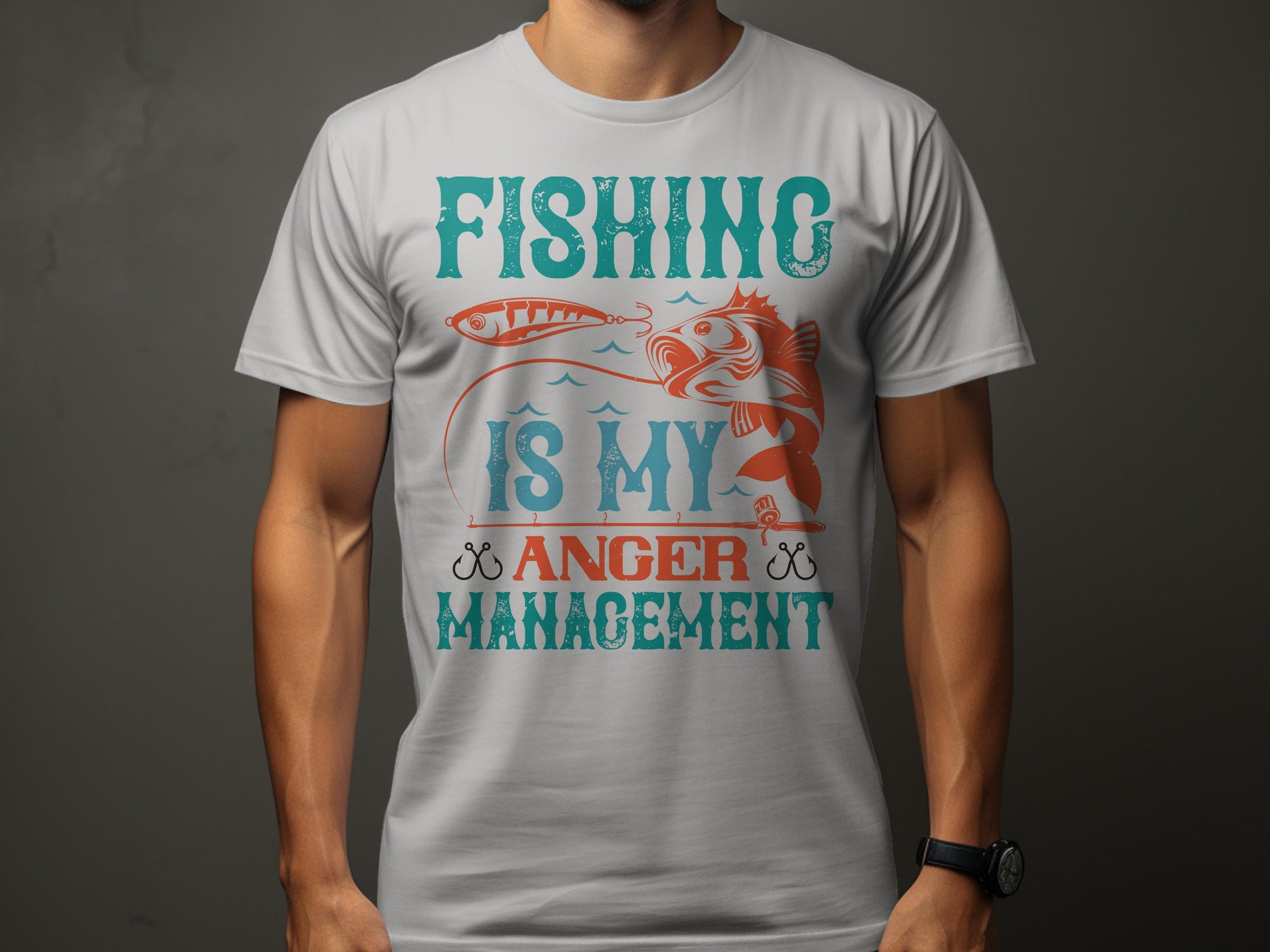 A fishing enthusiast wears a Garment Graphics gray T-shirt featuring a fish with the slogan Fishing is my Anger Management in vibrant teal and orange.