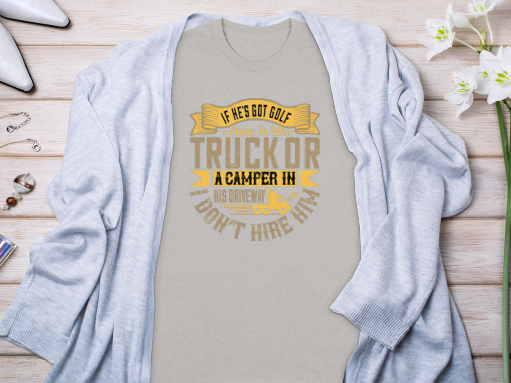 Light gray Garment Graphics t-shirt with the text If hes got golf clubs in his truck or a camper in his driveway, dont hire him in yellow and gray. Ideal for camping or golf fans, styled with a cardigan and surrounded by white flowers and jewelry.