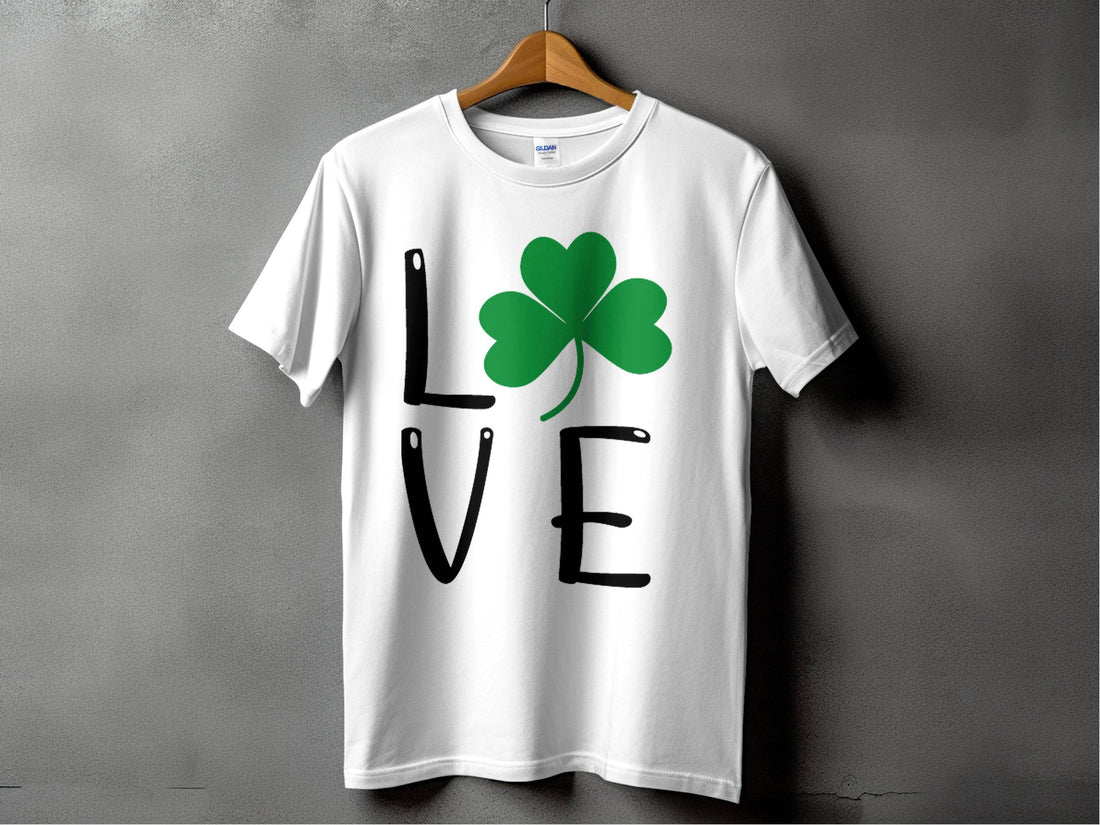 Garment Graphics presents a white T-shirt displaying the word LOVE, where a green shamrock artfully replaces the letter O, all set against a gray backdrop. This festive design is perfect for celebrating St. Patricks Day with Irish spirit and charm.