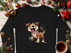 Garment Graphics black sweatshirt, perfect for dog lovers, showcases an animated happy dog illustration. It sits on a wooden surface surrounded by pine branches, red and gold ornaments, pine cones, a candy cane, and a steaming cup of coffee for a cozy festive feel.