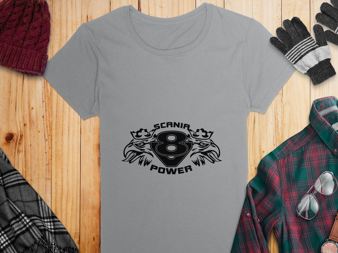 Wearing a light-colored T-shirt from Garment Graphics, the person showcases the SCANIA 8 POWER design, highlighted by stylized lions and eagle heads for an edgy effect. The face is not visible.