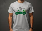 A person wears a Garment Graphics white t-shirt celebrating Irish pride, featuring a green pickup truck with shamrocks and Happy St. Patricks Day, set against a dark gray backdrop that enhances contrast, keeping the face hidden.