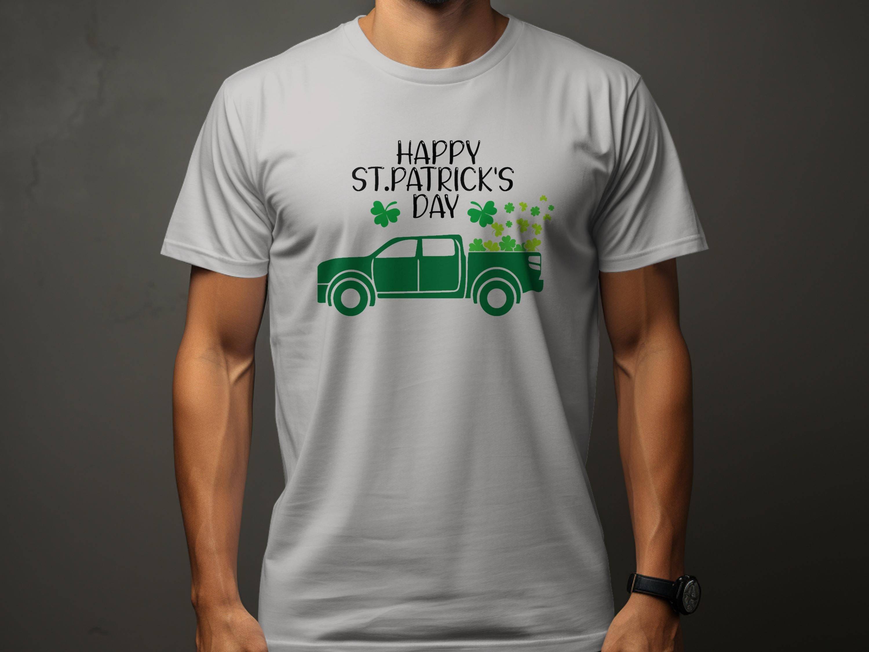 A person wears a Garment Graphics white t-shirt celebrating Irish pride, featuring a green pickup truck with shamrocks and Happy St. Patricks Day, set against a dark gray backdrop that enhances contrast, keeping the face hidden.