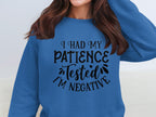 Someone is wearing a quirky, unisex Garment Graphics sweatshirt featuring the playful text I had my patience tested Im negative, ideal for casual outings. The persons face isnt visible.