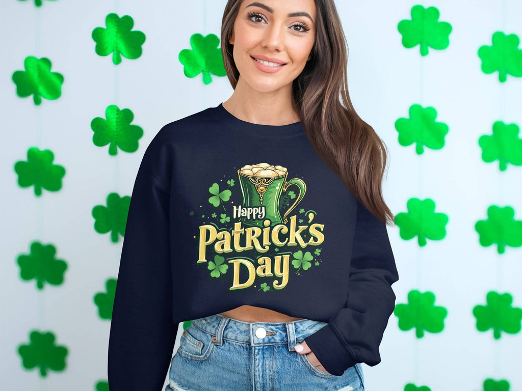 A woman beams in a Garment Graphics sweatshirt featuring a Happy St. Patricks Day design with a clover and beer mug, surrounded by green shamrocks on a light-colored backdrop.