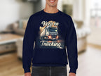 A person wears a Garment Graphics unisex graphic sweatshirt in dark blue, showcasing a large truck on a road with Keep On Trucking. The background shows a blurred indoor living space.