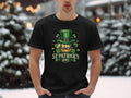 In a snowy setting, someone wears a Garment Graphics T-shirt for St. Patricks Day. The black shirt features a green shamrock and a bearded figure in a top hat, exuding Irish pride with the words St Patricks Day.