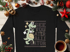Garment Graphics presents a playful black sweatshirt with an alligator spinning a basketball and the phrase SEE YOU LATER ALLIGATOR, adorned with Christmas ornaments and pine branches on wood.