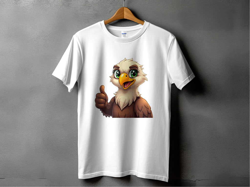 A Garment Graphics classic fit T-shirt hangs on a wooden hanger, featuring a cartoon eagle with large green eyes and a thumbs-up. This fun wardrobe staple pops against the solid gray wall.