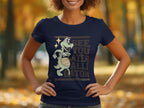 A woman wears a navy blue Garment Graphics Alligator T-Shirt, showcasing a cartoon alligator with a basketball. The shirt humorously reads, See you later alligator, set against blurred autumn trees with vibrant yellow leaves.