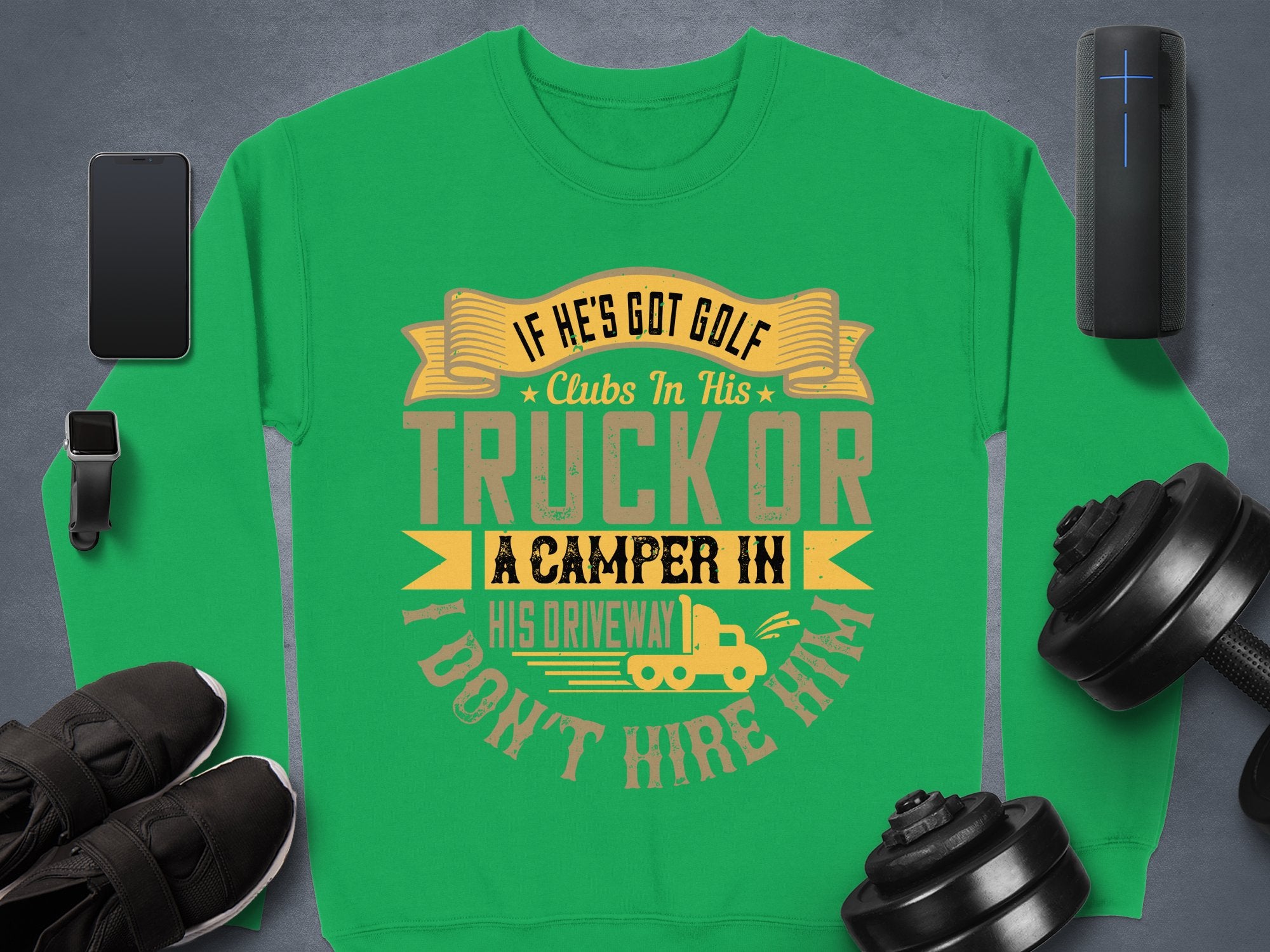 Garment Graphics offers a green sweatshirt proclaiming, IF HES GOT GOLF CLUBS IN HIS TRUCK OR A CAMPER IN HIS DRIVEWAY I DONT HIRE HIM, with a fun ribbon, golf club, and camper design. Ideal for casual wear, it pairs perfectly with sneakers, dumbbells, your phone, or speaker.
