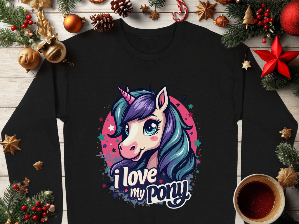 Garment Graphics offers a vibrant black sweatshirt design featuring a cartoon pony-unicorn with purple and blue hair in a colorful circle, text I love my pony, surrounded by holiday decorations, pine branches, and ornaments. Perfect for the season.