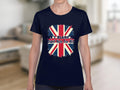 A person is seen wearing a striking navy T-shirt from Garment Graphics, featuring the Union Jack and Dont Blame Me, I Didnt Vote For Him on 100% cotton. The blurred indoor setting in neutral tones enhances the impact of the message.