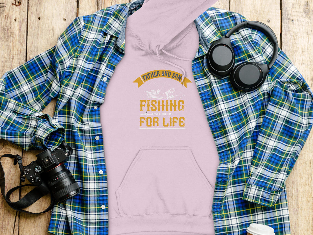 A fishing enthusiast wears a black Garment Graphics hoodie with Father and Son Fishing Partners for Life in striking yellow and white, featuring a fish and crossed rods—ideal for celebrating the father-son fishing bond.