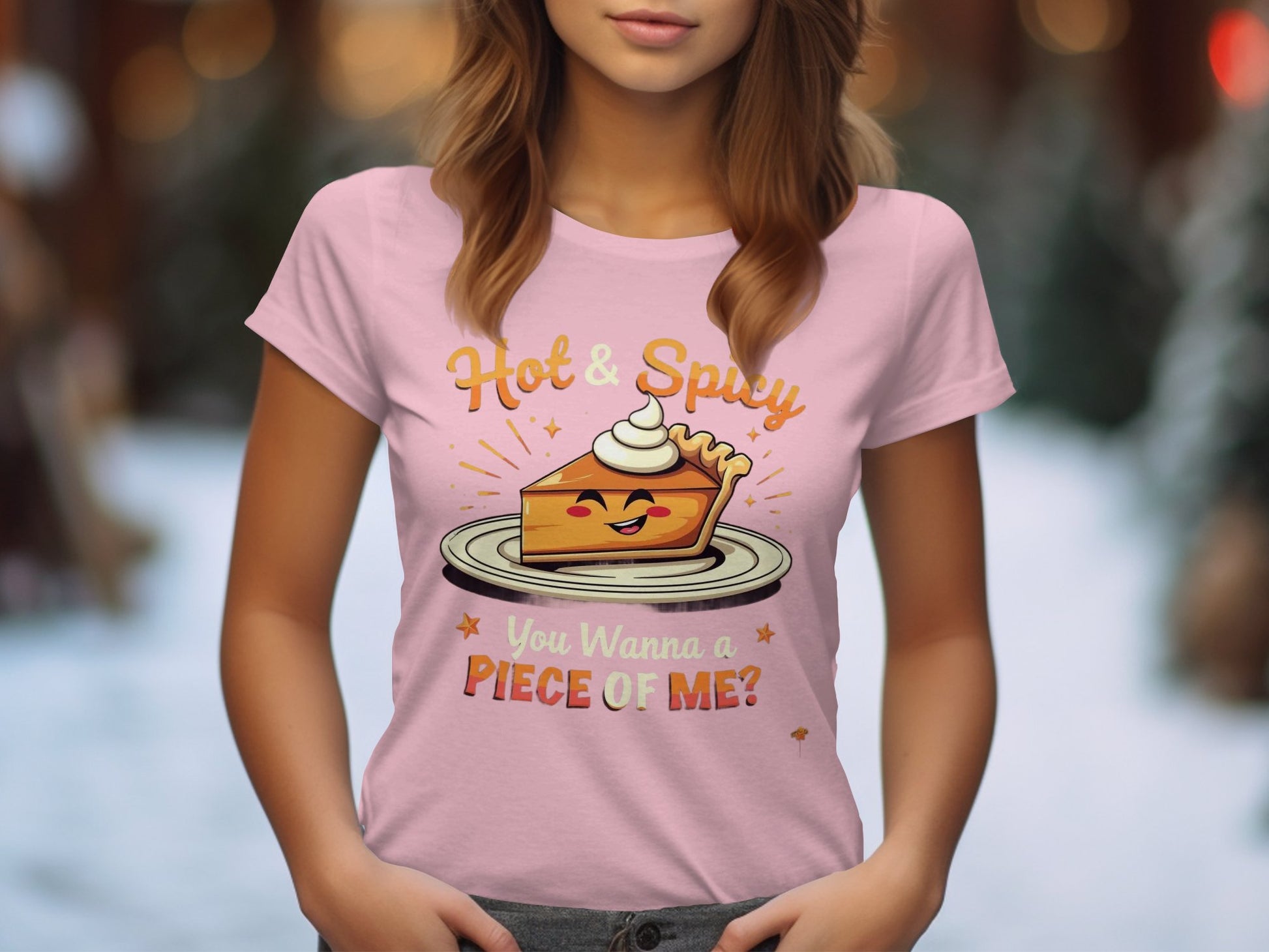 A woman wears a pink Garment Graphics T-shirt with a cartoon spicy pie and texts Hot & Spicy and You Wanna a Piece of Me?. The soft-focus snowy tree backdrop makes it ideal for casual outings.