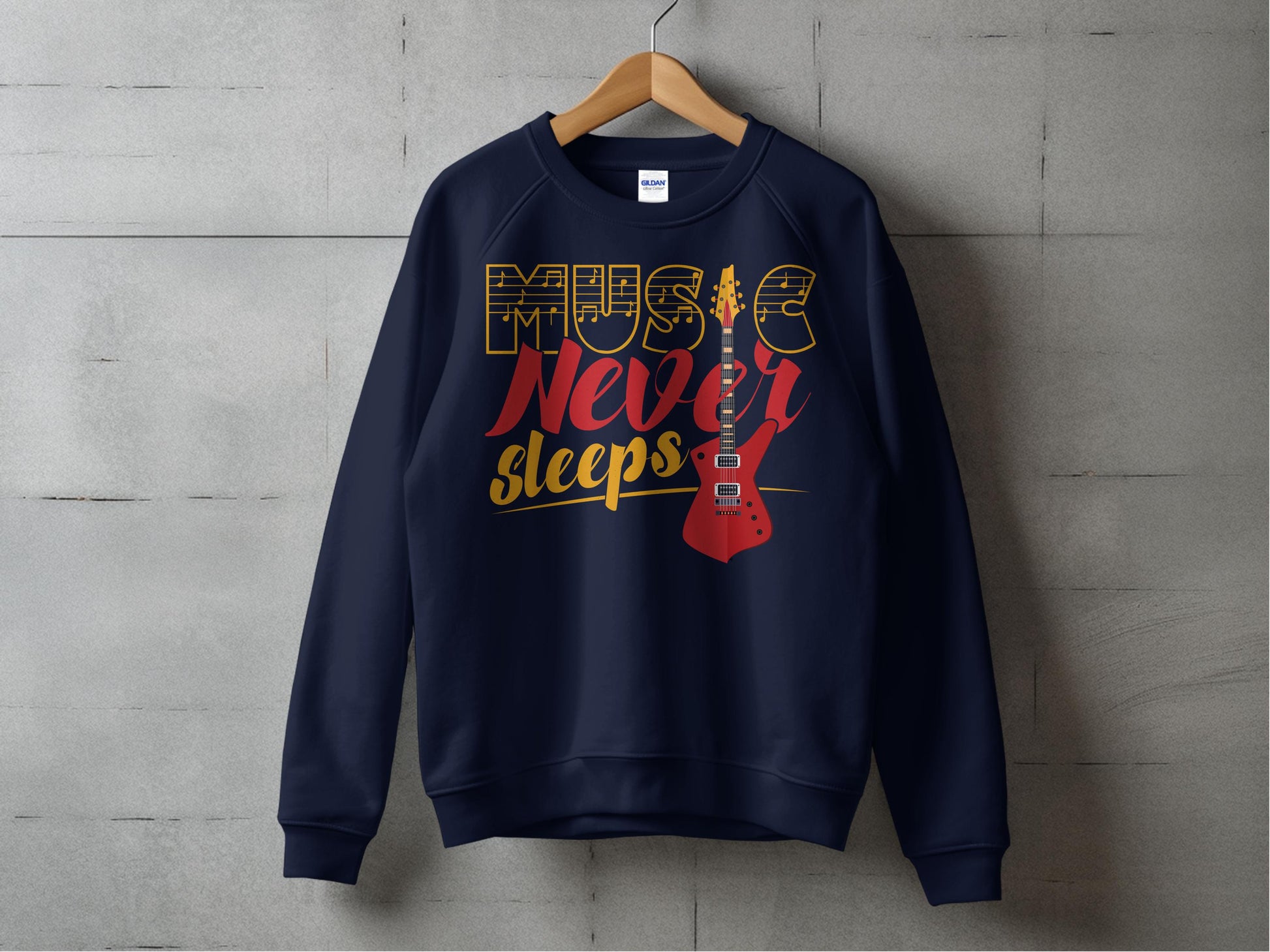 A vibrant navy blue sweatshirt by Garment Graphics hangs on a wooden hanger against a concrete wall. Perfect for music lovers, it features Music Never Sleeps in gold and red with an electric guitar illustration.