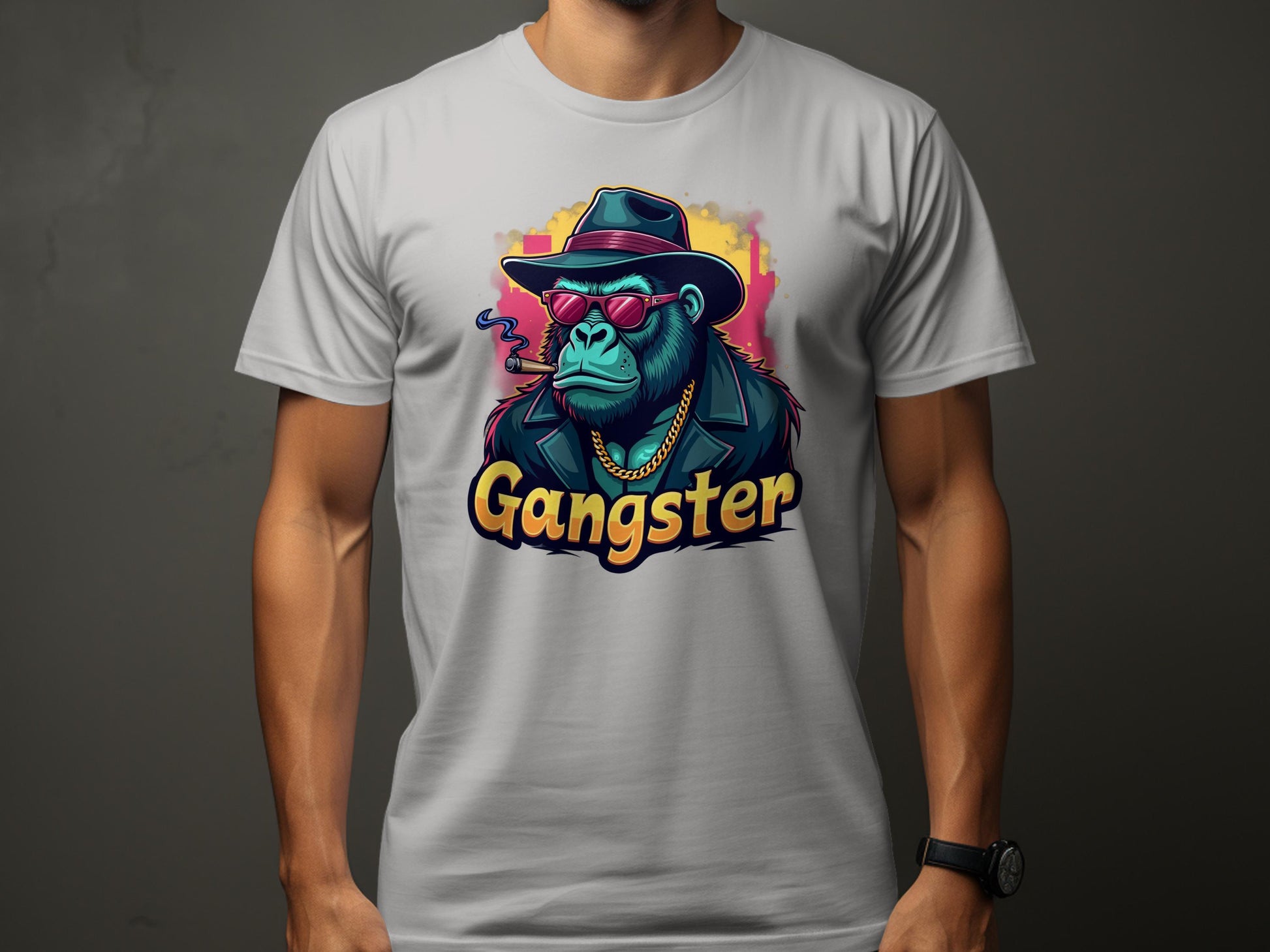 A person is sporting a white Garment Graphics Gangster Gorilla T-Shirt with urban style. This classic fit tee displays a gorilla dressed as a gangster—complete with hat, sunglasses, coat, gold chain, and smoking cigar. The word Gangster stands boldly beneath the illustration.