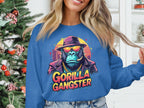 Wearing a Garment Graphics blue sweatshirt with a Gorilla Gangster in hat, sunglasses, and gold chain, someone stands by a festively decorated Christmas tree, showcasing an urban style.
