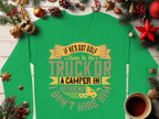 Amid festive decor like pinecones and ornaments, a cozy cup of coffee sits beside Garment Graphics green sweatshirt. It declares: If hes got golf clubs in his truck or a camper in his driveway, I dont hire him. Ideal for those who enjoy humor with an outdoorsy vibe.