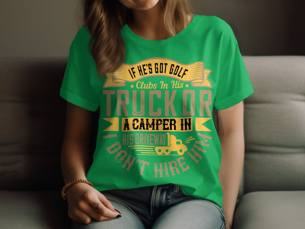 Someone is wearing a Garment Graphics green T-shirt featuring a humorous golf graphic: IF HES GOT GOLF CLUBS IN HIS TRUCK OR A CAMPER IN HIS DRIVEWAY I DONT HIRE HIM, with a small truck illustration. Paired with jeans, this quirky design comes in womens sizing for an ideal fit.
