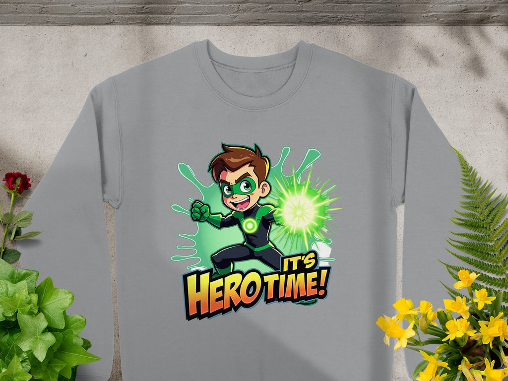 The Garment Graphics gray sweatshirt showcases a cartoon superhero with brown hair in a green suit, emitting green energy. The text Its Hero Time! is below. Decorated with vibrant plants and flowers, this unisex piece is perfect for fans of the genre.