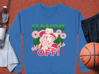 The Garment Graphics Wild Side Sweatshirt, unisex, boasts bold graphics of a hat-wearing figure pointing amid flowers with HANDS OFF! in bright green and red. Its styled on an orange backdrop with a water bottle, towel, black shorts, and a basketball.