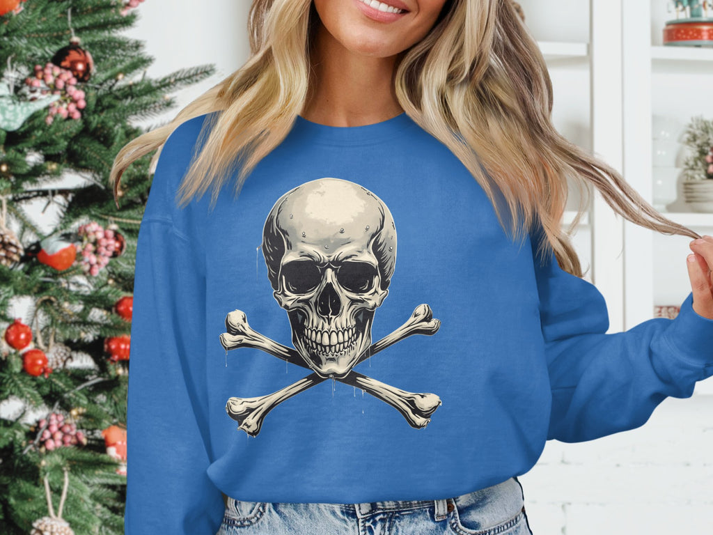 A person sporting an edgy look in a Garment Graphics blue sweatshirt featuring a skull and crossbones design stands by a decorated Christmas tree.