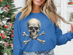 A person sporting an edgy look in a Garment Graphics blue sweatshirt featuring a skull and crossbones design stands by a decorated Christmas tree.