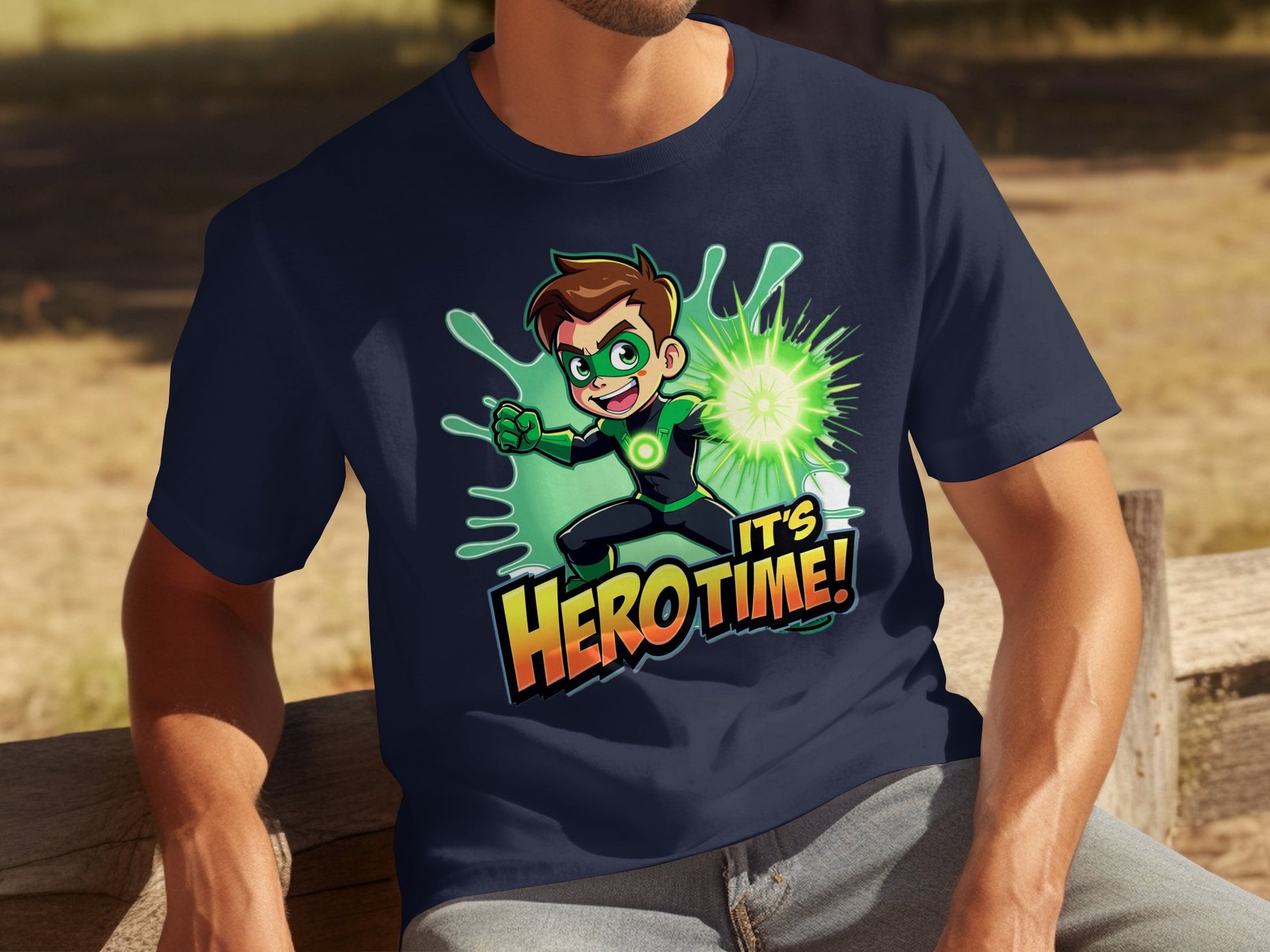 A person relaxes on a wooden bench outdoors, wearing a vibrant dark blue Garment Graphics T-shirt with a superhero graphic featuring a cartoon superhero in green and black and glowing text reading Its Hero Time!.
