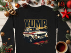 Garment Graphics black t-shirt features a vintage rally car with YUMP in bold letters, adorned with holiday decor including pine branches, pinecones, stars, ornaments, a candy cane, and a cozy coffee cup on wood.